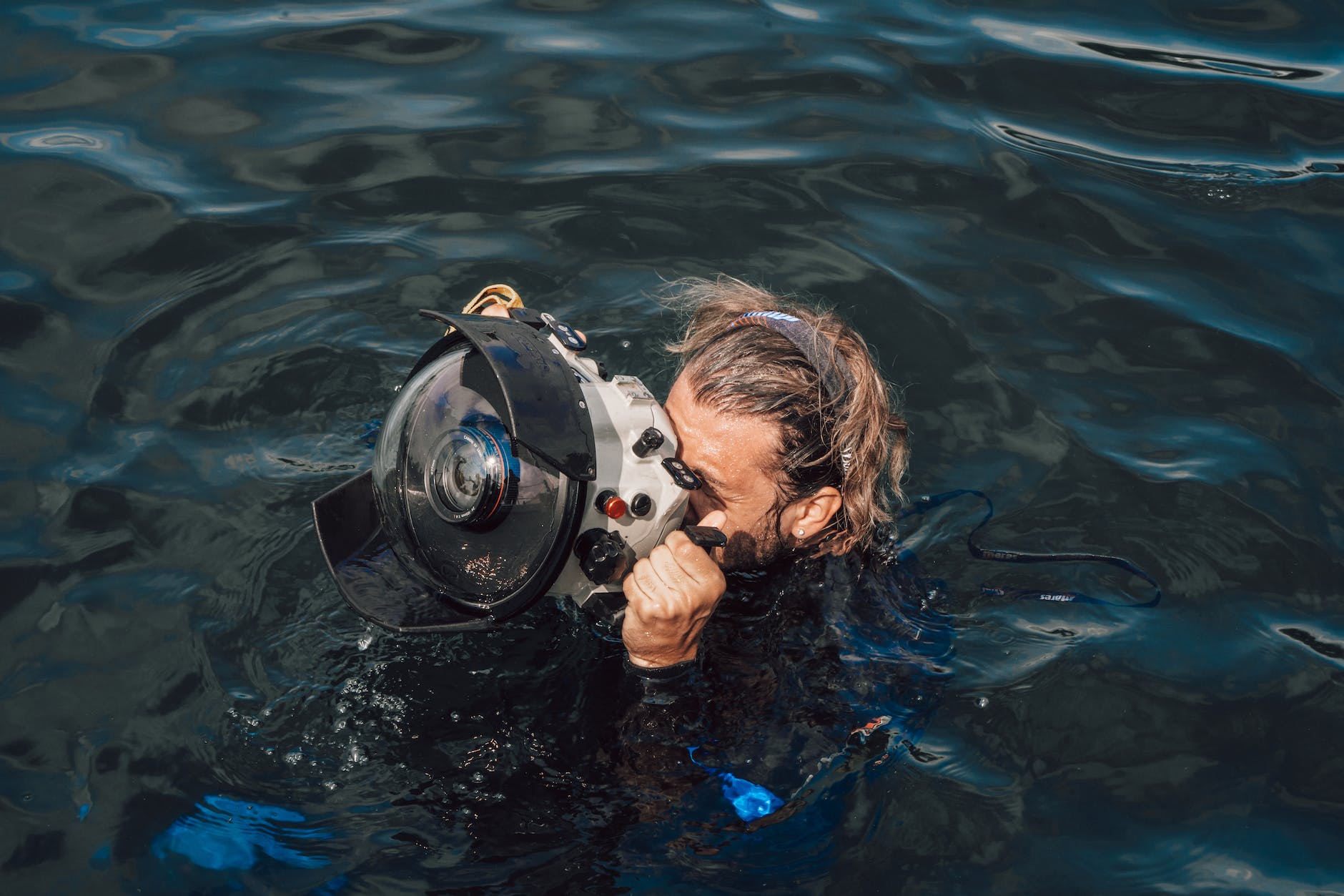 unrecognizable diver taking photo on equipment in aqua box